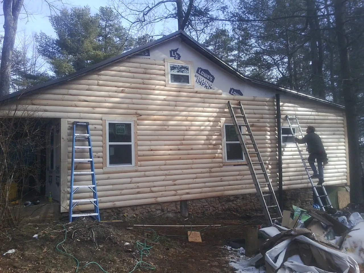 Ladders set against fresh log siding during an exterior remodel in Knoxville