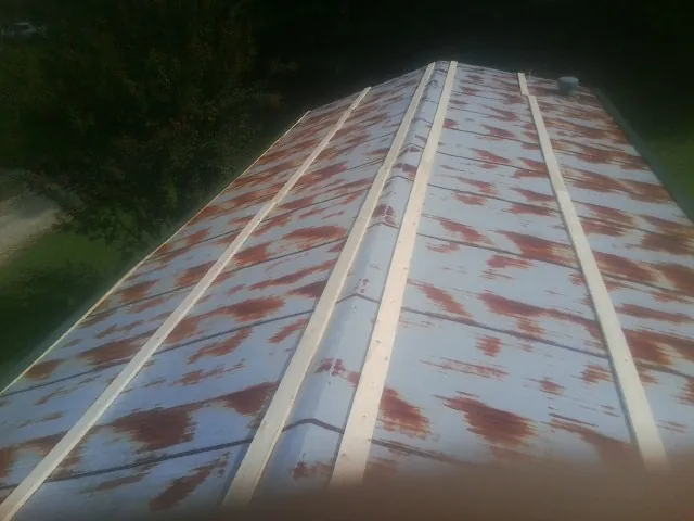 Rusted metal roof panels with new wood purlins before replacement — Storm Damage Roof Repair in Knoxville by Roofing Brothers