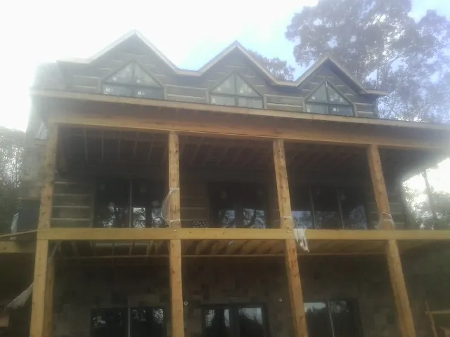 Dormers and porch framing on a large log home under construction — Roof Coating work by our crew in Knoxville